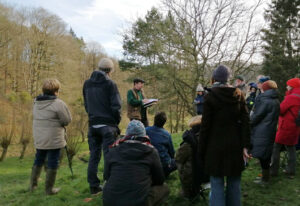 Un petit groupe discute des arbres dans un jardin