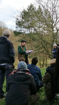 A small group discussing trees in a garden